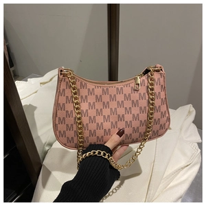 Detailed close-up of a pink crescent bag with black M-letter print and gold chain strap