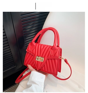 Detail der roten gesteppten kleinen Tasche mit V-Naht und goldenem Drehverschluss-Verschluss