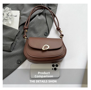 Brown vintage saddle bag detail showing compact size compared to a smartphone