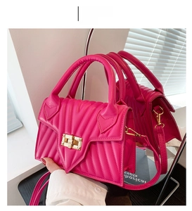Detail der fuchsiafarbenen Trapez-Handtasche mit V-Steppung und goldenem Quadratverschluss