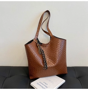 Detailed view of dark brown woven tote bag texture with elegant scarf accessory