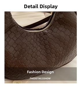 Close-up of deep brown woven texture and metallic zipper on crescent shoulder bag