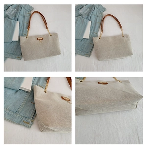 Detail view of woven tote bag with brown leather straps and gold deer charm