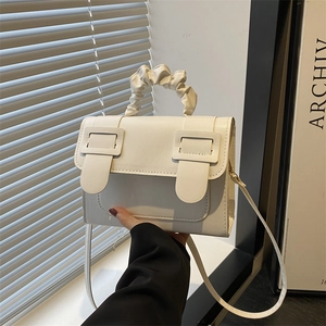 Minimalist white leather crossbody bag with pleated cloud handle and decorative buckles