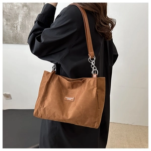 Close-up of caramel brown tote showing matte texture and silver chain strap detail