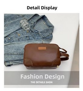 Détail de la trousse de toilette en cuir PU marron avec surpiqûres blanches et zip en métal