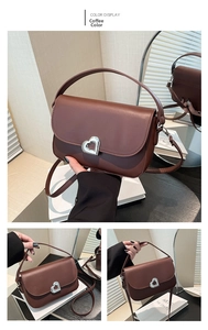 Detailed view of the brown saddle bag featuring a silver heart-shaped metal twist lock
