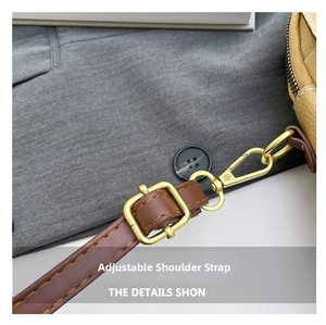Detail of adjustable brown leather shoulder strap with gold metal buckle and stitching