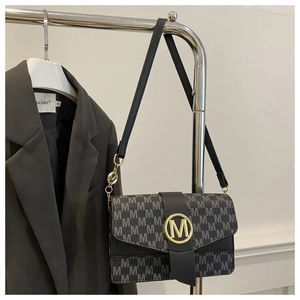 Detail of the black monogram shoulder bag with a gold metal M-shaped buckle