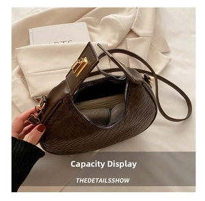 Detail view showing spacious interior of dark brown woven crescent bag with gold clasp