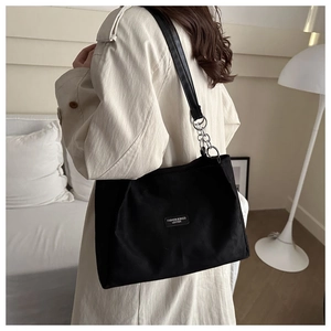 Detailed shot of large black leather tote bag with silver rings and fashion logo