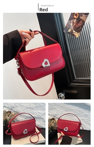 Detail of red leather shoulder bag with silver heart-shaped lock and detachable strap