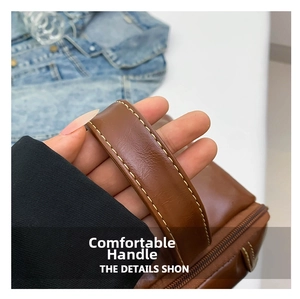 Gros plan du sac en cuir PU marron caramel montrant les coutures et les détails de l'anse