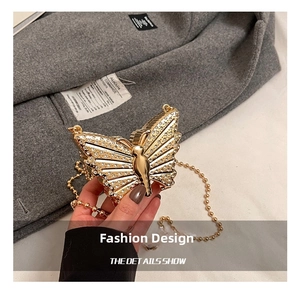 Detailed view of butterfly-shaped evening bag with sparkling rhinestones and gold chain