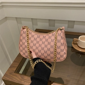 Pink crescent moon shoulder bag with M pattern print and gold chain strap handle