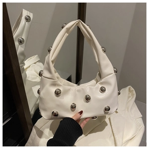 Detail of white half-moon bag featuring silver metal studs and pleated leather texture