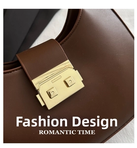 Detailed close-up of dark brown leather shoulder bag with a polished gold rectangle clasp