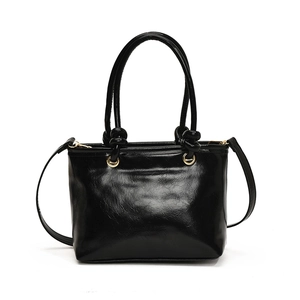 Sac à main minimaliste en cuir noir brillant avec garnitures dorées et bandoulière