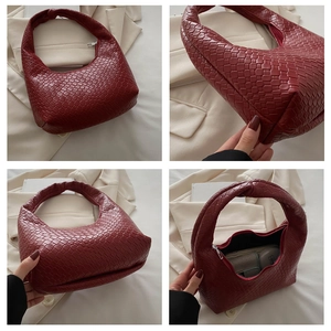 Detail view of woven dark red hobo bag showing texture, knot handle and interior space