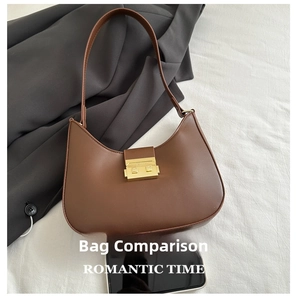 Brown leather half-moon shoulder bag with a gold metal clasp shown next to a smartphone