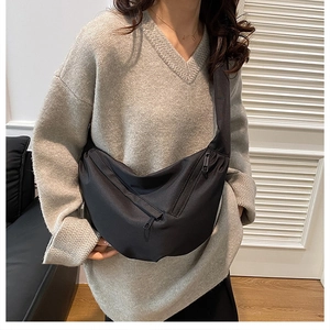Dettaglio della borsa a tracolla nera a mezzaluna con cerniere metalliche in nylon