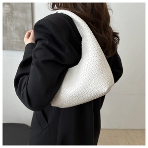 Close-up of white woven hobo bag showing intricate texture and half-moon design details