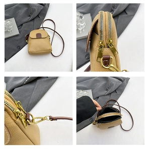 Detail view of lychee pattern small crossbody bag with dual metal zippers and front pocket