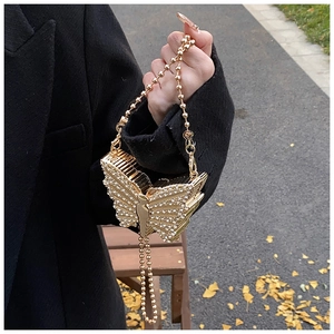 Détail du sac de soirée papillon doré avec cristaux scintillants et bandoulière chaîne