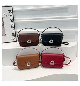 Detail showing colorful leather saddle bags with heart-shaped silver metal clasps