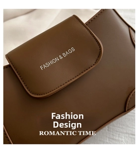 Close-up of brown vintage crossbody bag featuring white fashion text and fine stitching