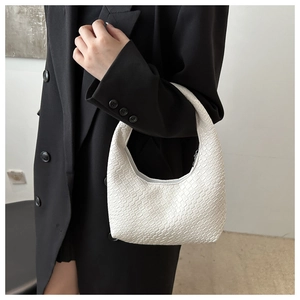 White woven Hobo bag close-up on shoulder with minimalist style and modern texture