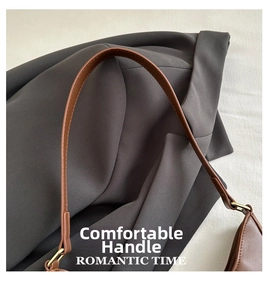 Detailed close-up of dark brown leather shoulder strap with golden metal hardware