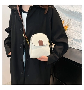 Close-up of white lychee textured crossbody phone bag with brown strap and golden hooks