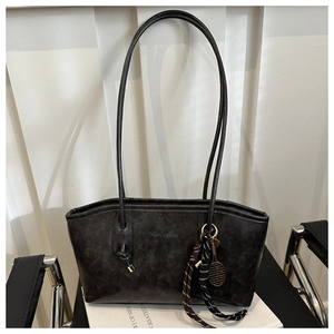 Detail of vintage black tote bag with tennis racket charm and fashion embossed text