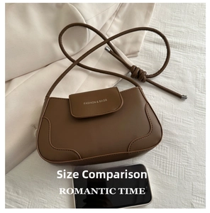 Brown leather crossbody bag size comparison with a smartphone on textured fabric