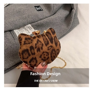 Detail of leopard print cat-shaped handbag with crystal clasp and gold chain strap