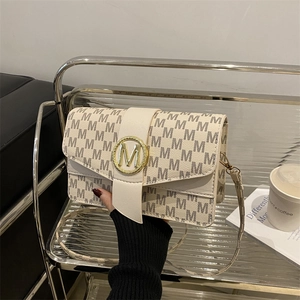 French chic monogram shoulder bag in beige fabric with gold M buckle worn by model