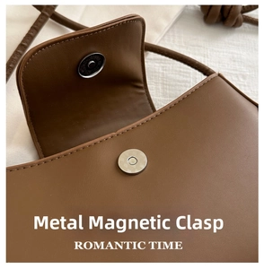 Detailed view of the magnetic metal buckle and premium brown leather texture of the handbag