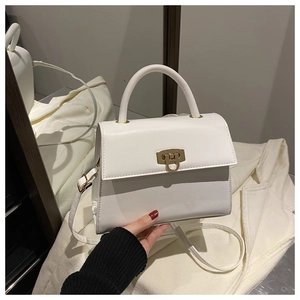 Detailansicht der weißen minimalistischen Handtasche mit goldener Schließe und Leder