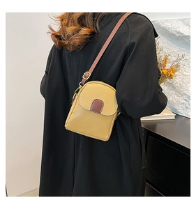 Detail of mustard yellow lychee pattern crossbody bag with brown leather strap and gold hardware