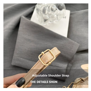 Detail of an adjustable beige faux leather shoulder strap with a golden square buckle