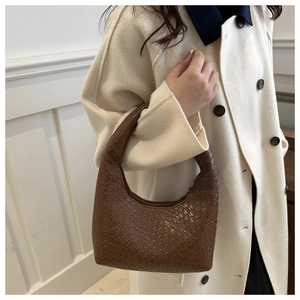 Detail of dark brown woven texture and crescent hobo design on a stylish tote bag