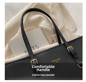 Detail of black Saffiano tote bag showing gold logo and adjustable buckle handle
