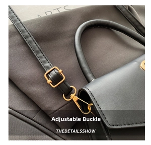 Detail of golden metal buckle and stitching on a black leather vintage shoulder bag