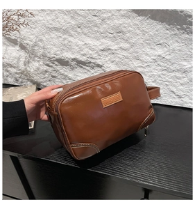 Gros plan sur la trousse de toilette en cuir PU marron avec logo LEKE et zip double