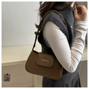 Detail of a dark brown leather underarm bag with white Fashion & Bags lettering print