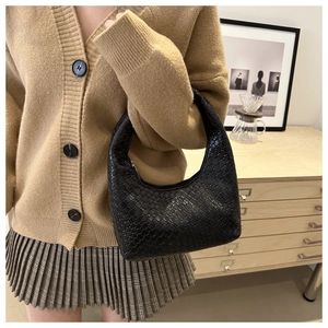 Close-up of black woven leather shoulder bag with intricate Intrecciato texture