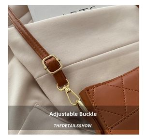 Détail macro d'une bandoulière en cuir marron avec boucle dorée réglable et motif matelassé