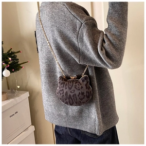 Detail view of cat-shaped leopard print crossbody bag with gold chain and gem closure