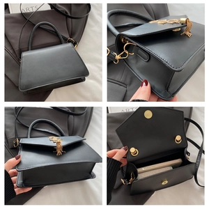 Detailed view of black flap crossbody bag with gold hardware, fringe charm and interior space